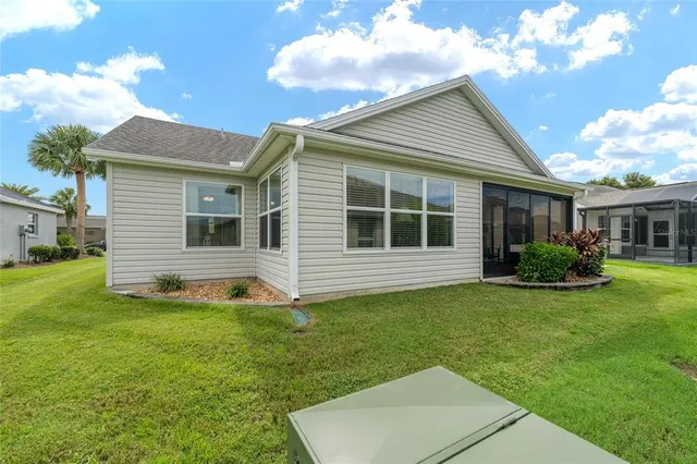 a front view of a house with a yard and potted plants