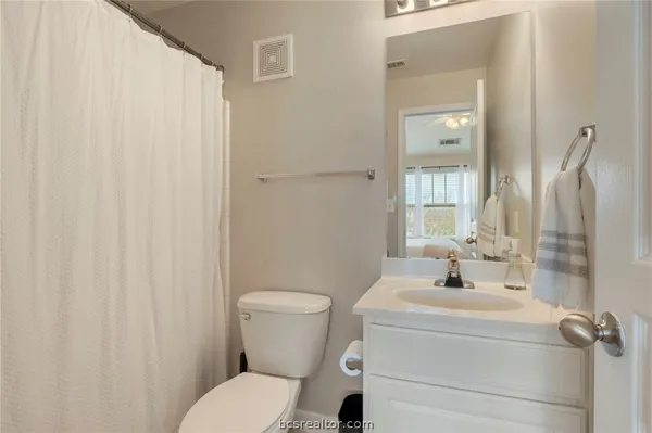 a bathroom with a sink a toilet and shower curtain