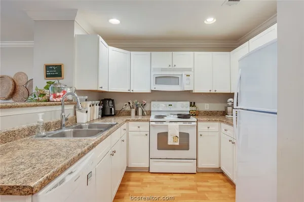 a kitchen with stainless steel appliances granite countertop a sink stove and white cabinets