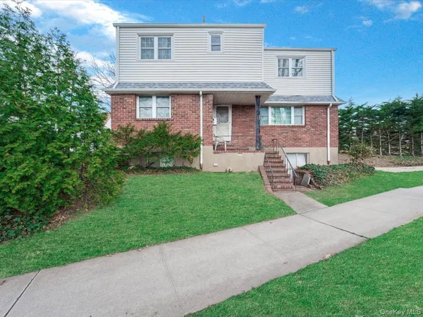 a view of a house with a yard and sitting area