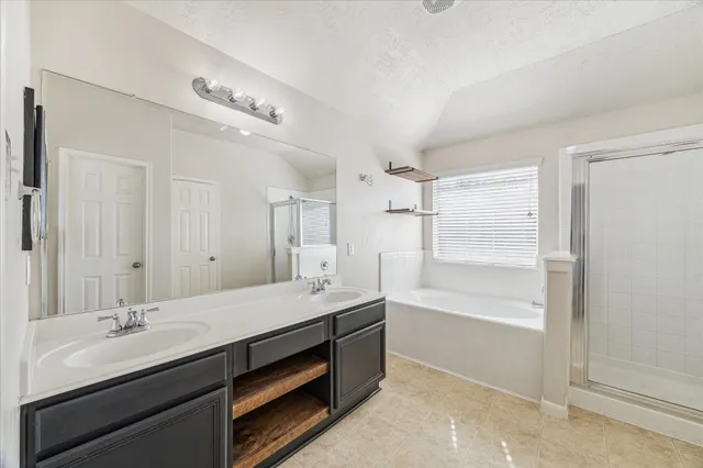 a bathroom with a tub double sink and mirror