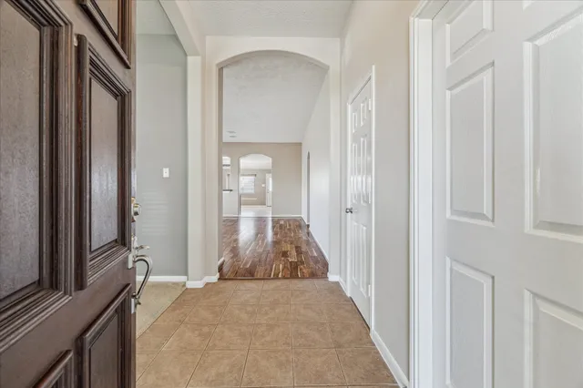 a view of a hallway with wooden floor and a living room