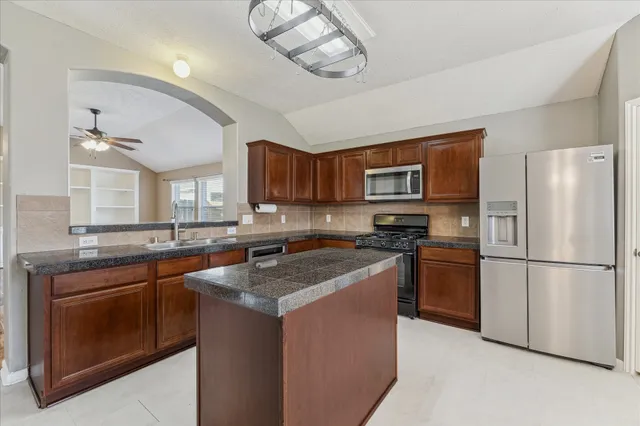 a kitchen with stainless steel appliances granite countertop a stove a sink dishwasher a refrigerator and a microwave oven