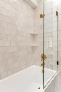 a white bath tub sitting next to a shower