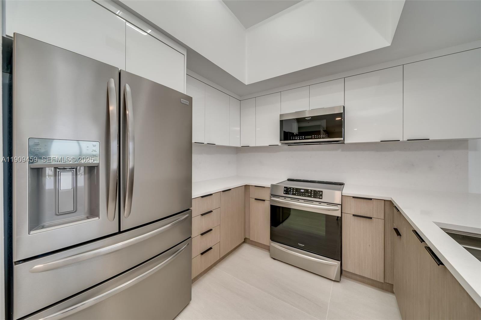 140 South Dixie Highway, Unit 1007 Hollywood, FL 33020 - Photo 6 of 32 a kitchen with granite countertop white cabinets and stainless steel appliances