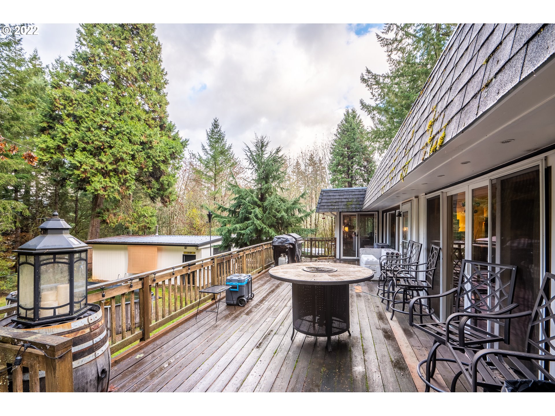 39845 Deerhorn Road Springfield, OR 97478 - Photo 25 of 29 a view of a patio with table and chairs with wooden floor and fence
