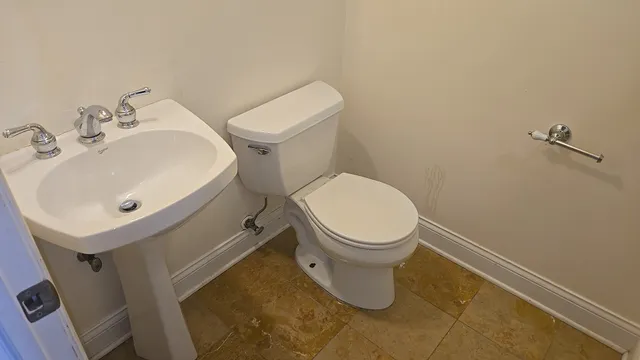 a white toilet sitting next to a bathroom sink