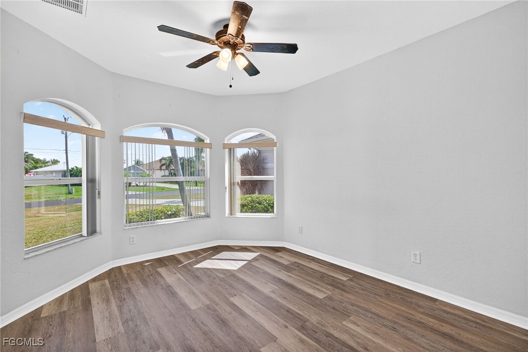 2007 Southwest 43rd Terrace Cape Coral, FL 33914 - Photo 12 of 22 an empty room with wooden floor fan and windows