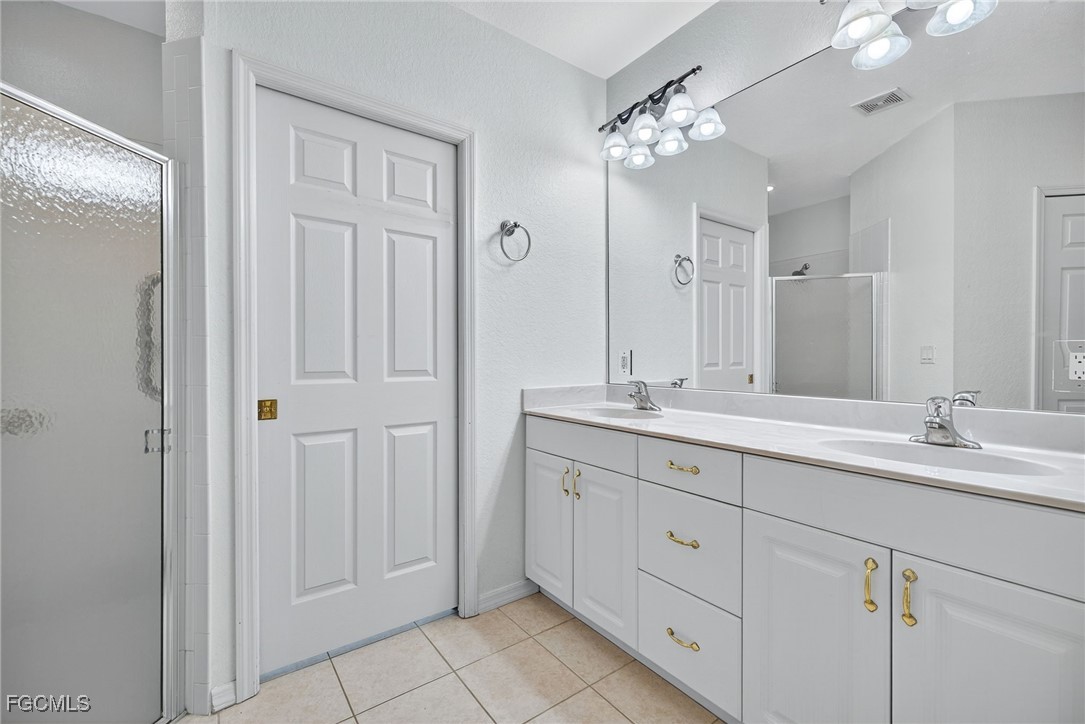 2007 Southwest 43rd Terrace Cape Coral, FL 33914 - Photo 14 of 22 a spacious bathroom with a granite countertop sink a mirror and a shower