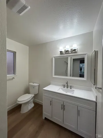 a bathroom with a double vanity sink toilet and mirror