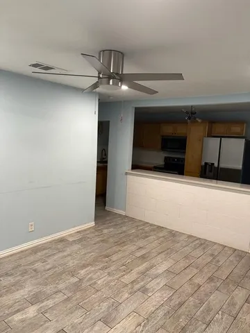 a view of a livingroom with a ceiling fan and wooden floor