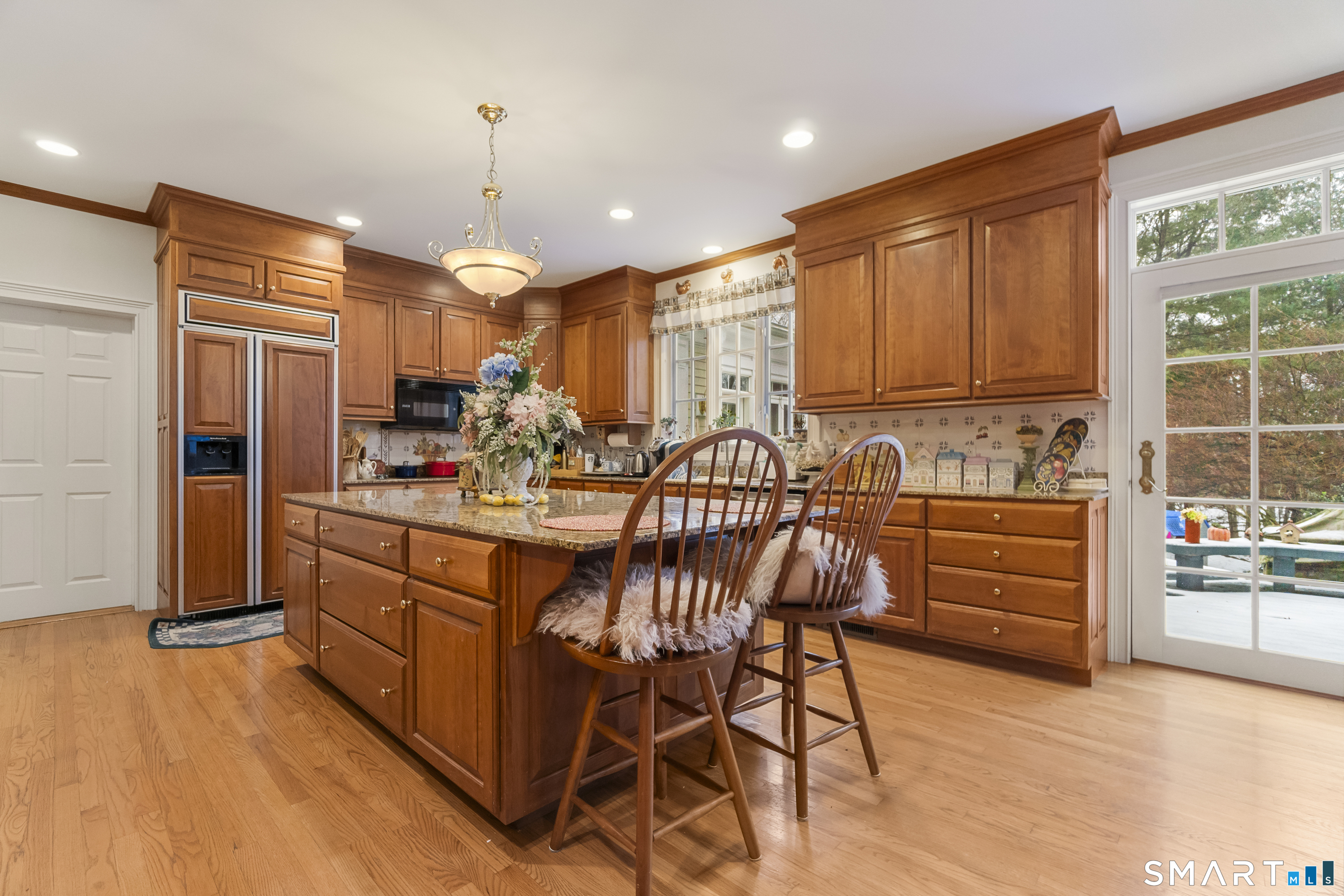 9 Perkins Road Woodbridge, CT 06525 - Photo 9 of 39 a kitchen with stainless steel appliances kitchen island granite countertop a stove a refrigerator and a microwave oven with large wooden cabinets