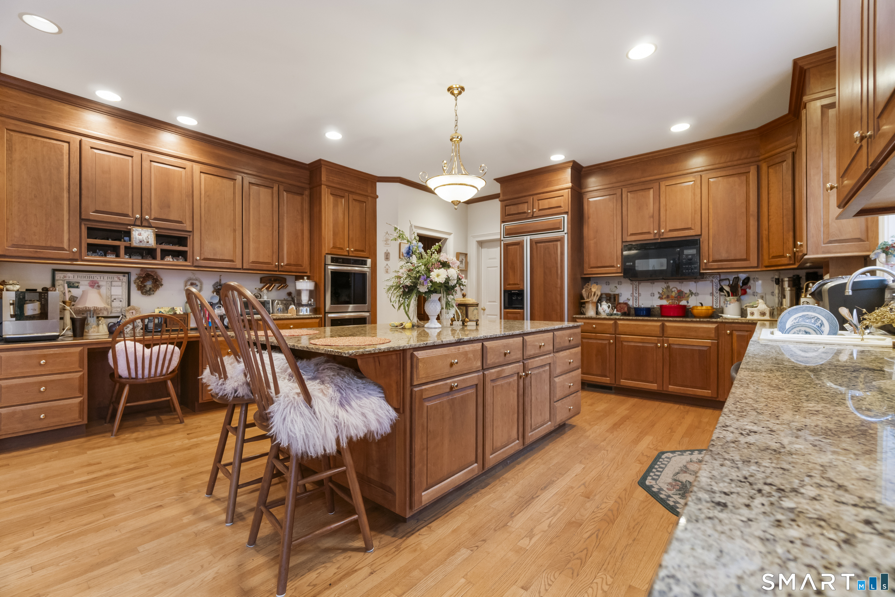 9 Perkins Road Woodbridge, CT 06525 - Photo 10 of 39 a kitchen with stainless steel appliances granite countertop a stove top oven a sink a stove a dining table and chairs
