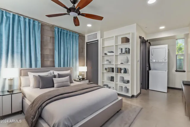 a bedroom with a large bed and a chandelier