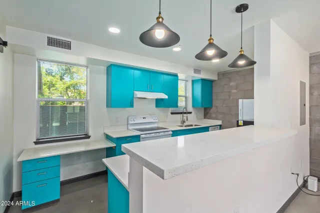 a kitchen with a sink a center island and stainless steel appliances