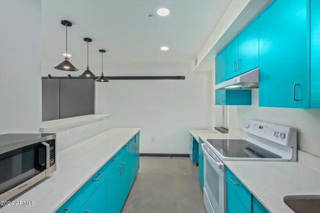 a kitchen that has a sink and a stove with wooden floor