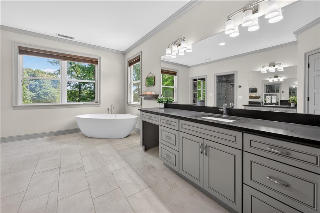 632 Geiger Road Jefferson, GA 30549 - Photo 29 of 55 a spacious bathroom with a double vanity sink a large mirror a bathtub and next to a window