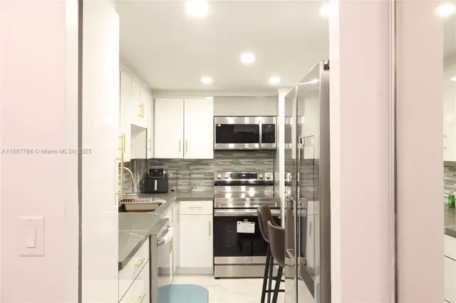 a kitchen with sink a refrigerator and cabinets