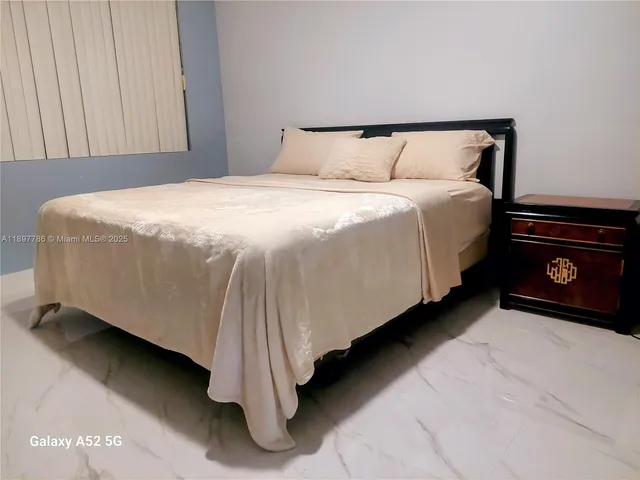 a bed sitting in a bedroom next to a cabinet