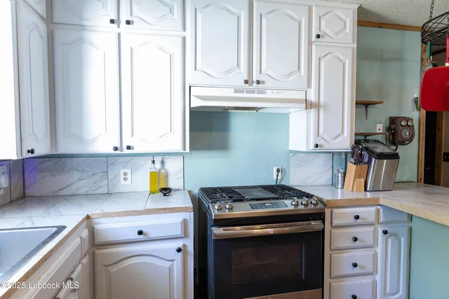 a kitchen with stainless steel appliances granite countertop a sink stove and cabinets