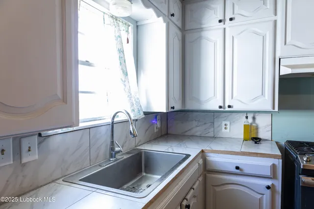 a kitchen with a sink cabinets and window