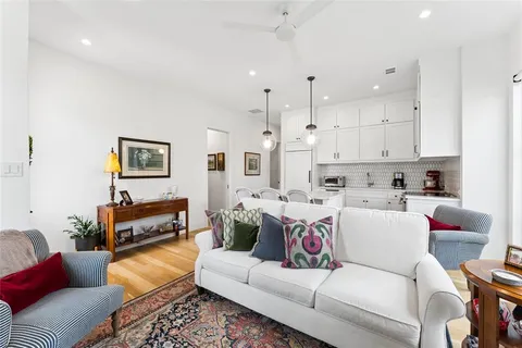 a living room with furniture and kitchen view