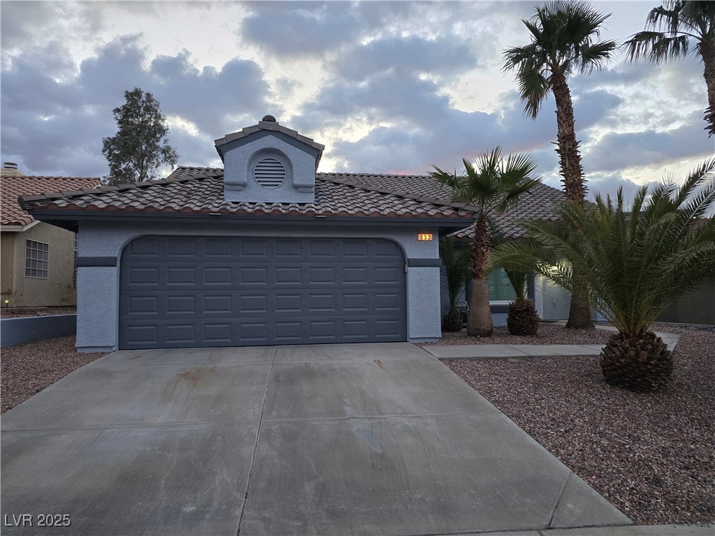 853 Rusty Anchor Way Henderson, NV 89002 - Photo 75 of 76 View of front facade with a tile roof, driveway, stucco siding, and an attached garage