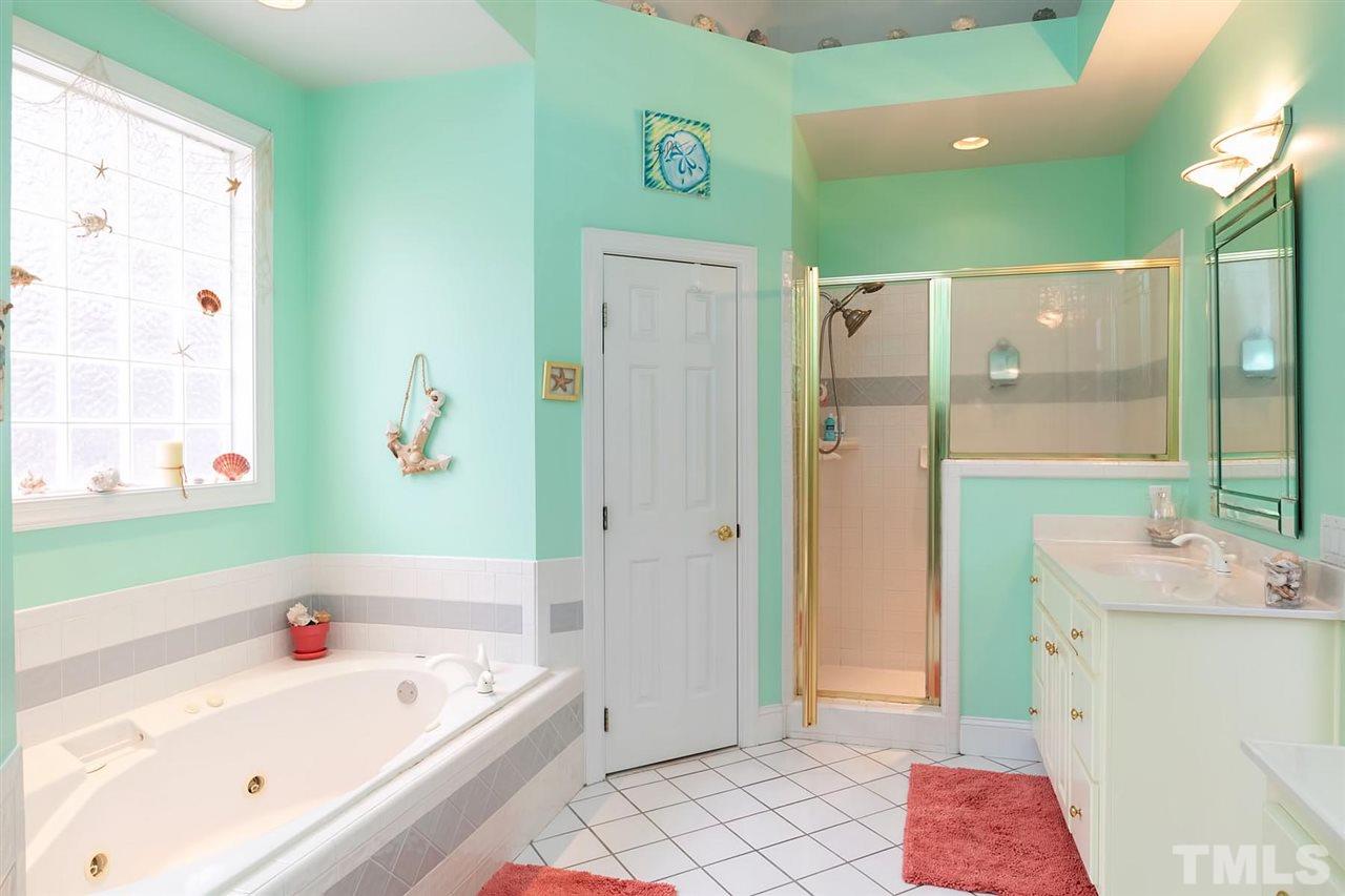 5912 Dean Avenue Raleigh, NC 27616 - Photo 8 of 24 a bathroom with a tub a sink and a large mirror