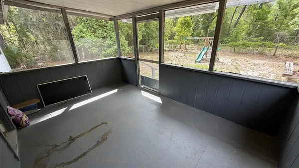 an empty room with wooden floor and entryway