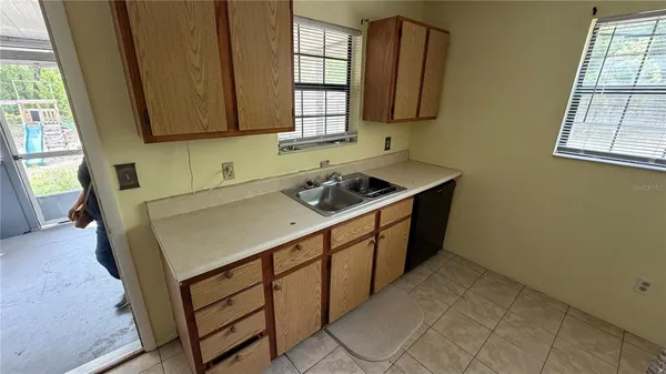 an empty room with windows and cabinet