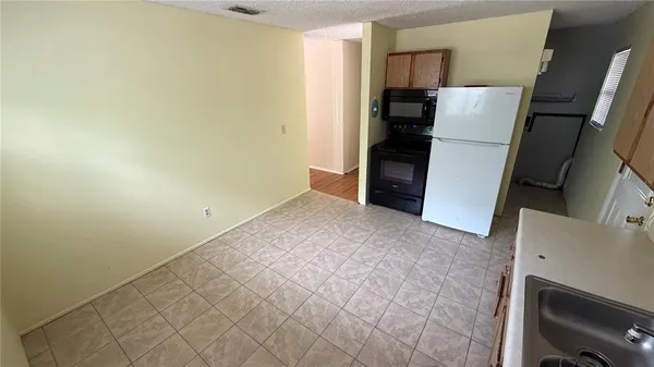 an empty room with wooden floor closet and windows