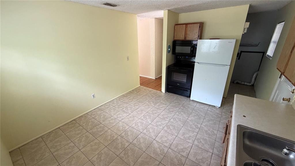 107 Eliam Road Melrose, FL 32666 - Photo 18 of 62 a view of a kitchen with a refrigerator cabinets and a ceiling fan