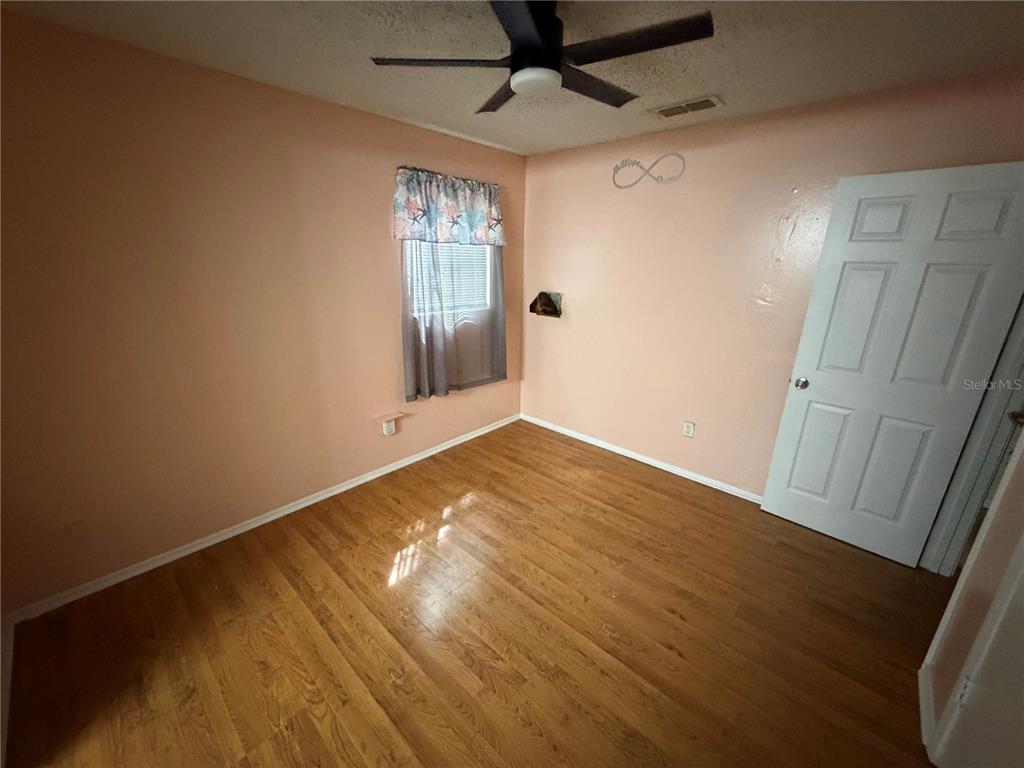 107 Eliam Road Melrose, FL 32666 - Photo 25 of 62 en empty room with wooden floor and windows