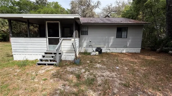 a view of a lake with a yard and large trees