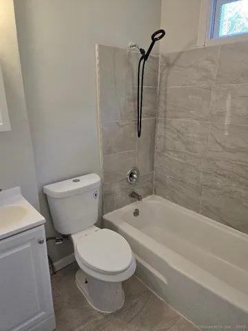 a white toilet sitting next to a bath tub and a shower
