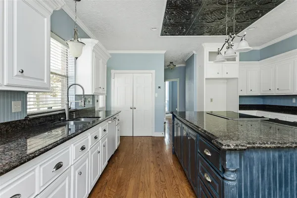 a kitchen with granite countertop a sink stove and cabinets