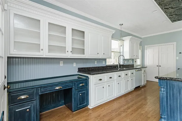 a kitchen with granite countertop white cabinets and stainless steel appliances