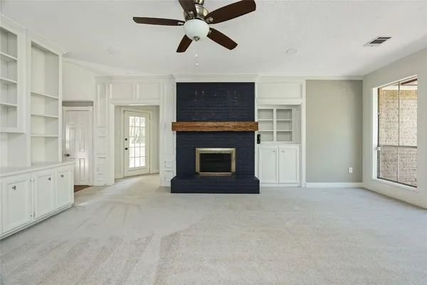 a view of an empty room with window and fireplace