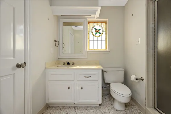 a bathroom with a granite countertop sink toilet a mirror and shower