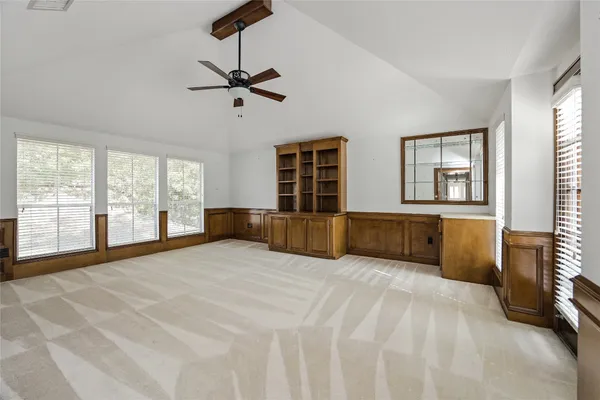 a view of an empty room with window and cabinet