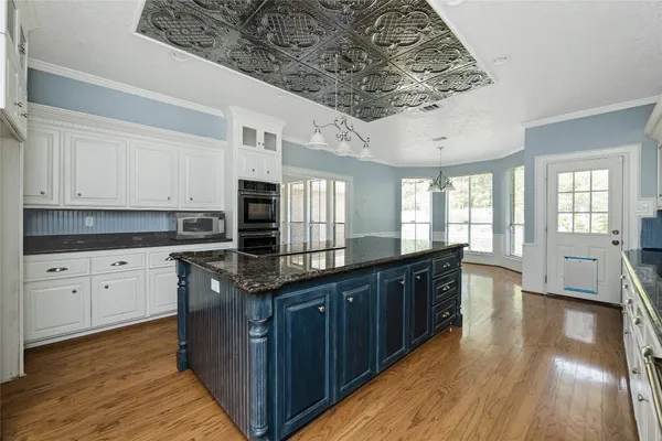 a kitchen with stainless steel appliances granite countertop a stove top oven a sink dishwasher and cabinets with wooden floor