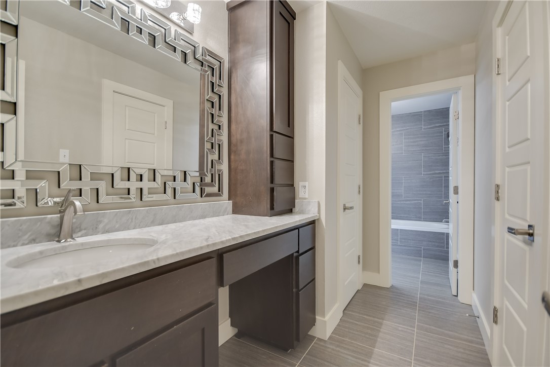 3513 Grimes Ranch Road Austin, TX 78732 - Photo 15 of 32 Bathroom featuring vanity, a tub to relax in, baseboards, and tile patterned flooring