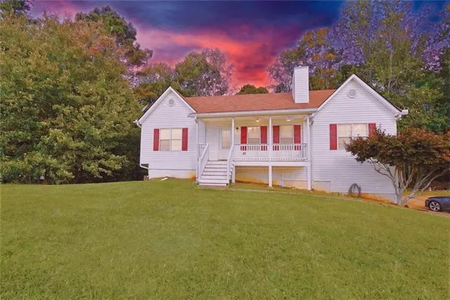 a front view of a house with a garden and yard