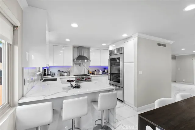 a kitchen with stainless steel appliances a sink stove and refrigerator