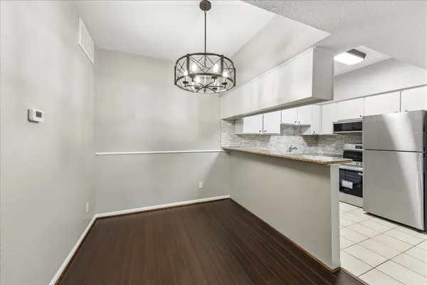 a kitchen with stainless steel appliances granite countertop a sink and a refrigerator