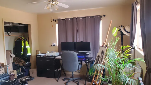 a view of a workspace with furniture and a window