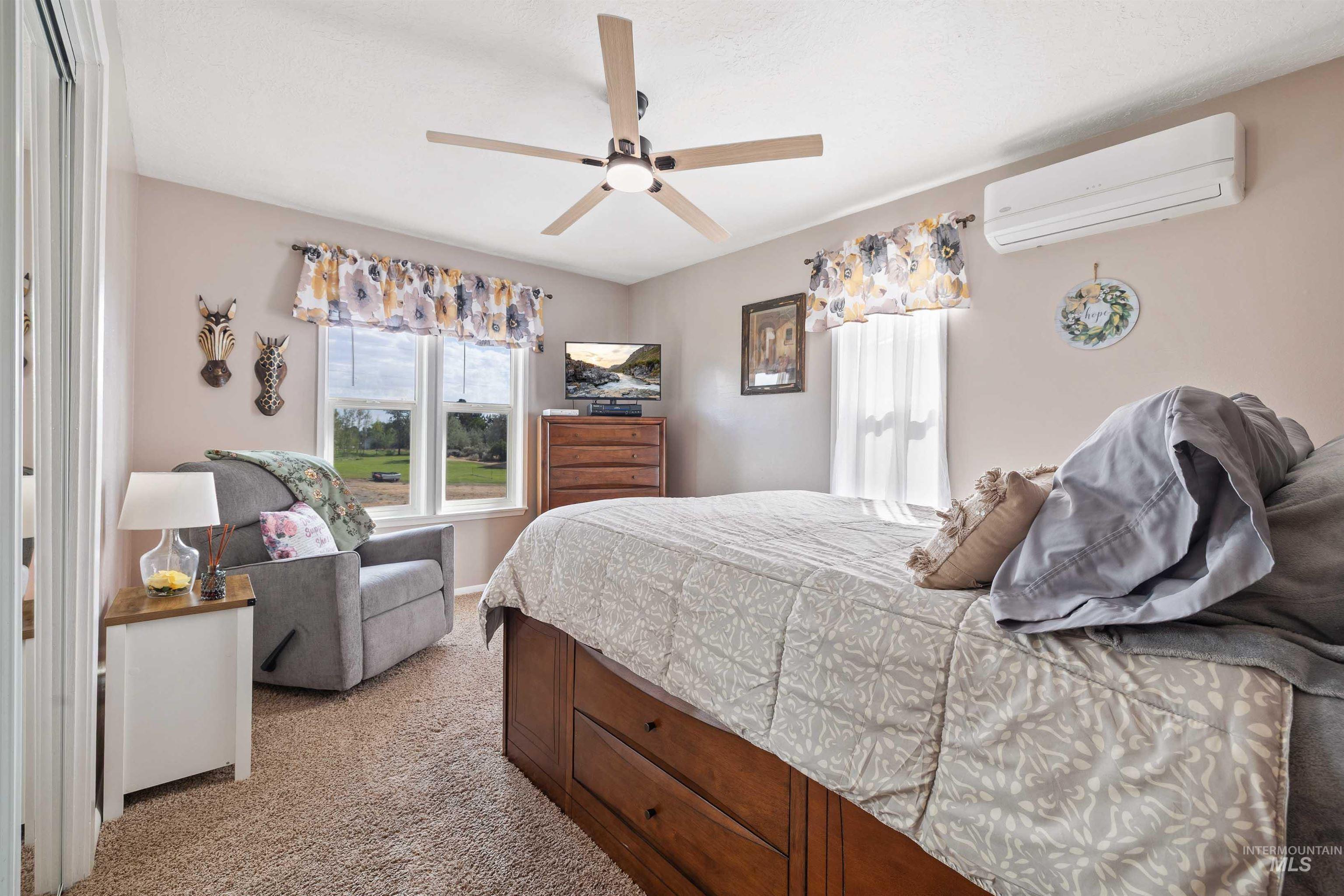 216 Ranch View Road West Jerome, ID 83338 - Photo 18 of 42 Carpeted flooring, ceiling fan with integrated lighting, multiple windows, and a wall-mounted climate control unit