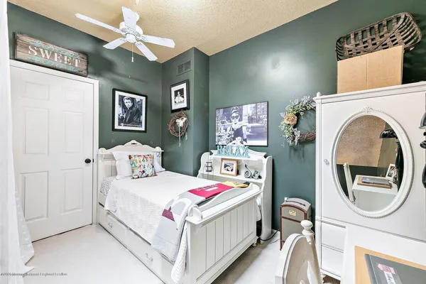 a bedroom with a bed a mirror and a table in it