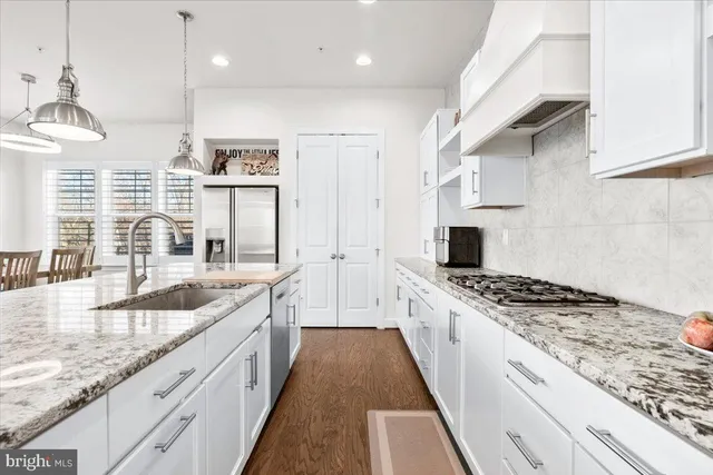 a large kitchen with stainless steel appliances granite countertop a lot of counter space and a sink