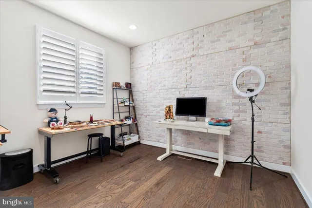 a view of a workspace with furniture and a window